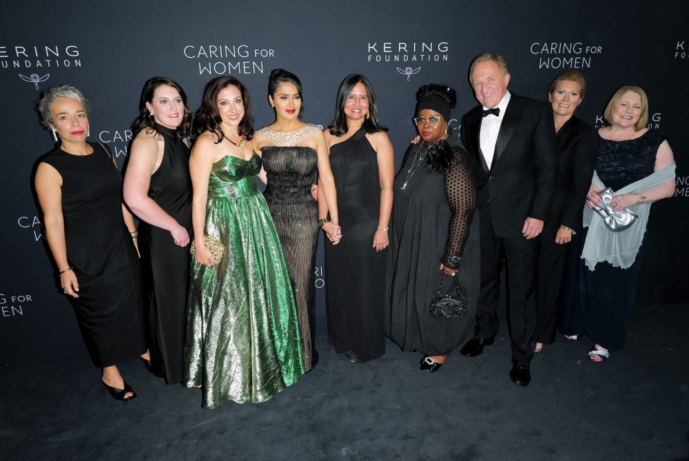 Article Banner - A group of people in fancy dress stand for a photo at the Caring for Women gala.