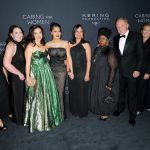 Article Banner - A group of people in fancy dress stand for a photo at the Caring for Women gala.