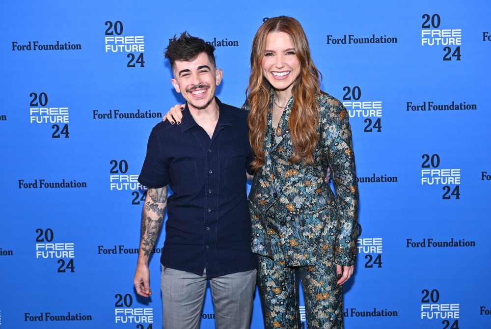 Article Banner - Sophia Bush, wearing a floral suit, stands with Chase Strangio, wearing a navy short-sleeve button-up and grey pants, in front of a background with the Ford Foundation and Free Future 2024 logos.