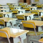 Desks in an empty school classroom.
