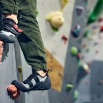 The feet of a rock climber scaling a wall.